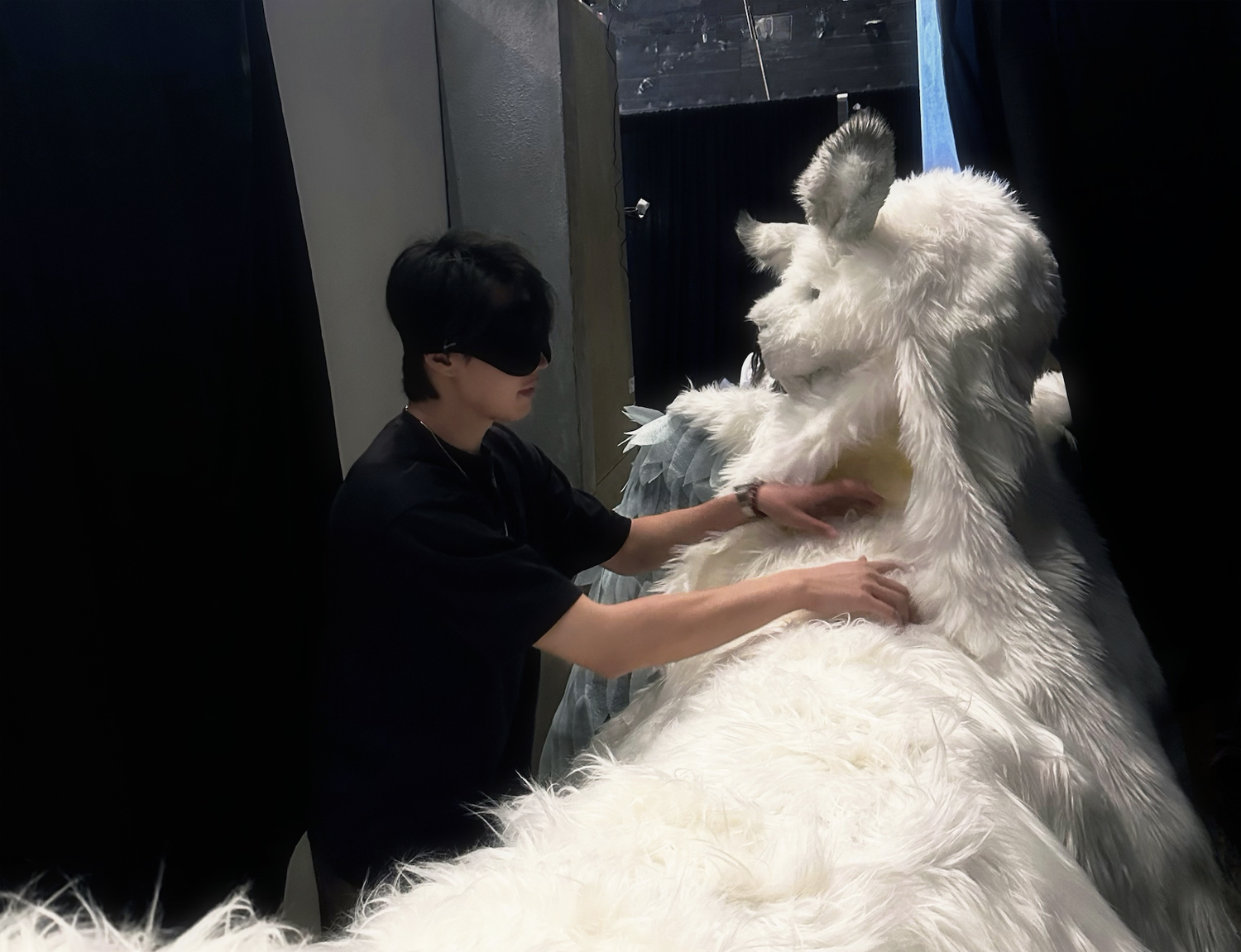 A blindfolded player gently touching Omu's chest